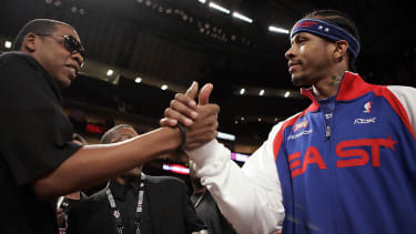 FILE - Rapper Jay-Z, left, shakes hands with NBA All-Star Philadelphia 76ers' Allen Iverson before the start of the NBA All-Star basketball game in Houston, Feb. 19, 2006. Just as a movie soundtrack helps viewers follow the action of the narrative through each plot twist, hip-hop has done the same for basketball via the NBA. A legacy was passed to Iverson when he entered the NBA in 1996, embodying hip-hop culture in everything he did, from his clothes to his corn rows. (AP Photo/LM Otero, file)