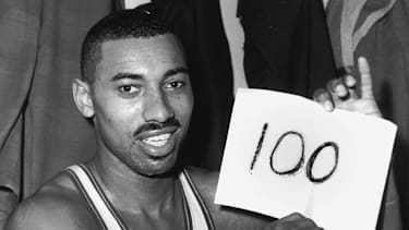 Wilt Chamberlain hält einen Zettel mit der Zahl 100 hoch.