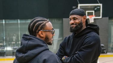 Los Angeles Lakers draft pick Bronny James, left, and his father, LeBron James, share a light moment as they arrive for the NBA basketball team's news conference in El Segundo, Calif., Tuesday, July 2, 2024. (AP Photo/Damian Dovarganes)